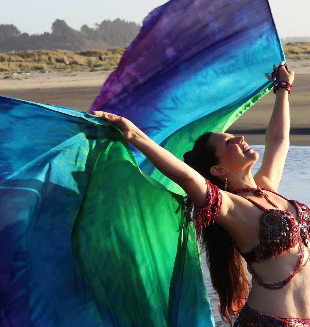 Dancer with tie-dye veil at the beach